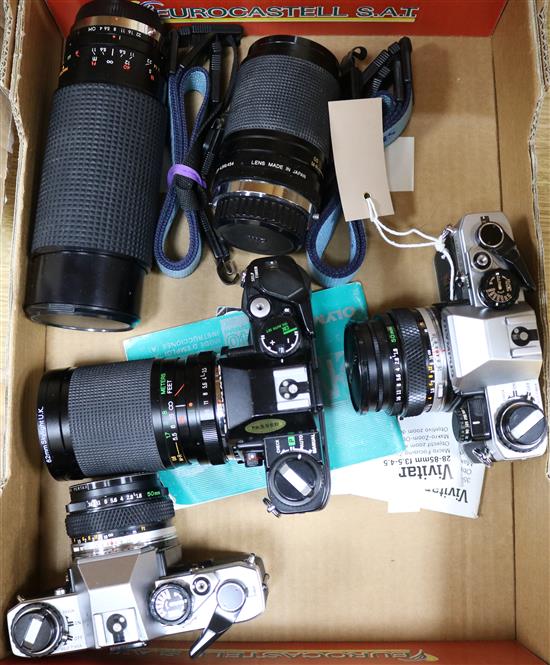 Three Olympus SLR cameras and two telephoto lenses